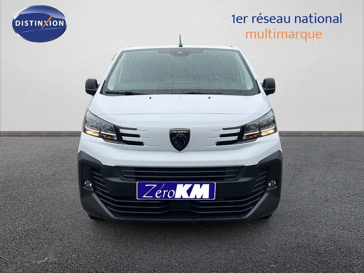 Vue avant d’un Peugeot Expert Fourgon blanc 2025 avec calandre noire et phares allumés sur fond neutre.