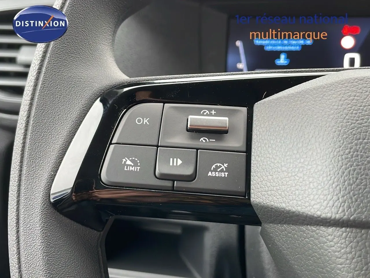 Gros plan sur les commandes au volant du Peugeot Expert Fourgon blanc, version 2025, avec boutons de régulateur et limiteur.