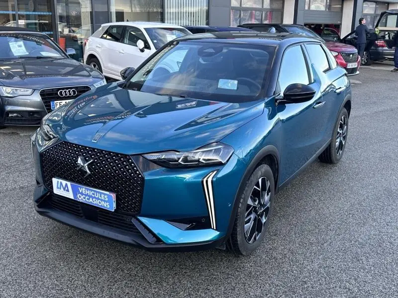 Vue 3/4 avant d'une DS3 1.2 Hybride bleu avec calandre noire à motifs losanges et feux LED verticaux distinctifs.