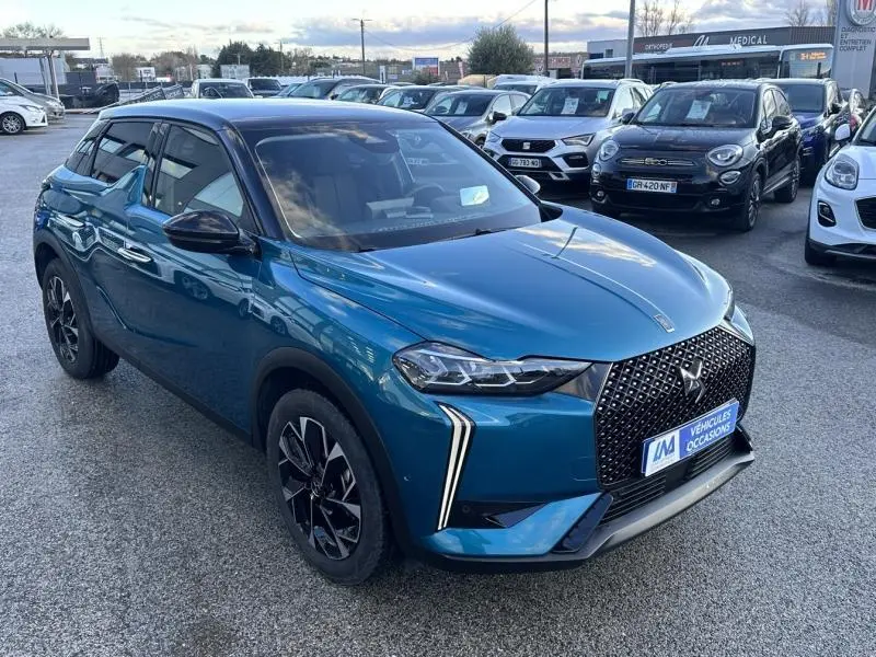 DS3 1.2 Hybride bleu en 3/4 avant droit, avec calandre distinctive et feux LED verticaux.