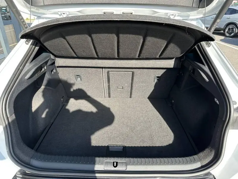 Coffre ouvert vu de l'arrière d'une CUPRA Formentor blanc Nevada métallisé, espace de chargement vide et propre.