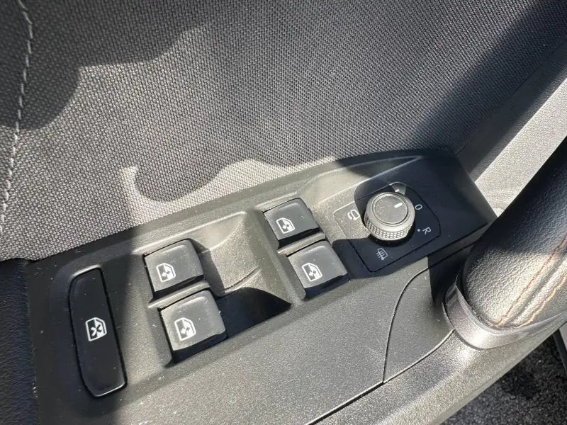 Détail des commandes des vitres et rétroviseurs côté conducteur du CUPRA Formentor blanc Nevada 2025.