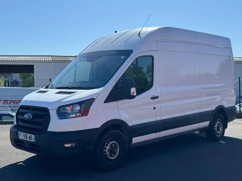 Fourgon Ford Transit blanc glacier vu en 3/4 avant droit, avec calandre noire et phares modernes à LED.