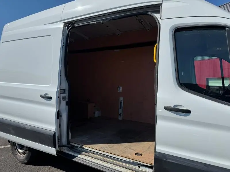Vue latérale gauche d'un Ford Transit Fourgon blanc Glacier avec porte coulissante ouverte dévoilant l'espace de chargement vide