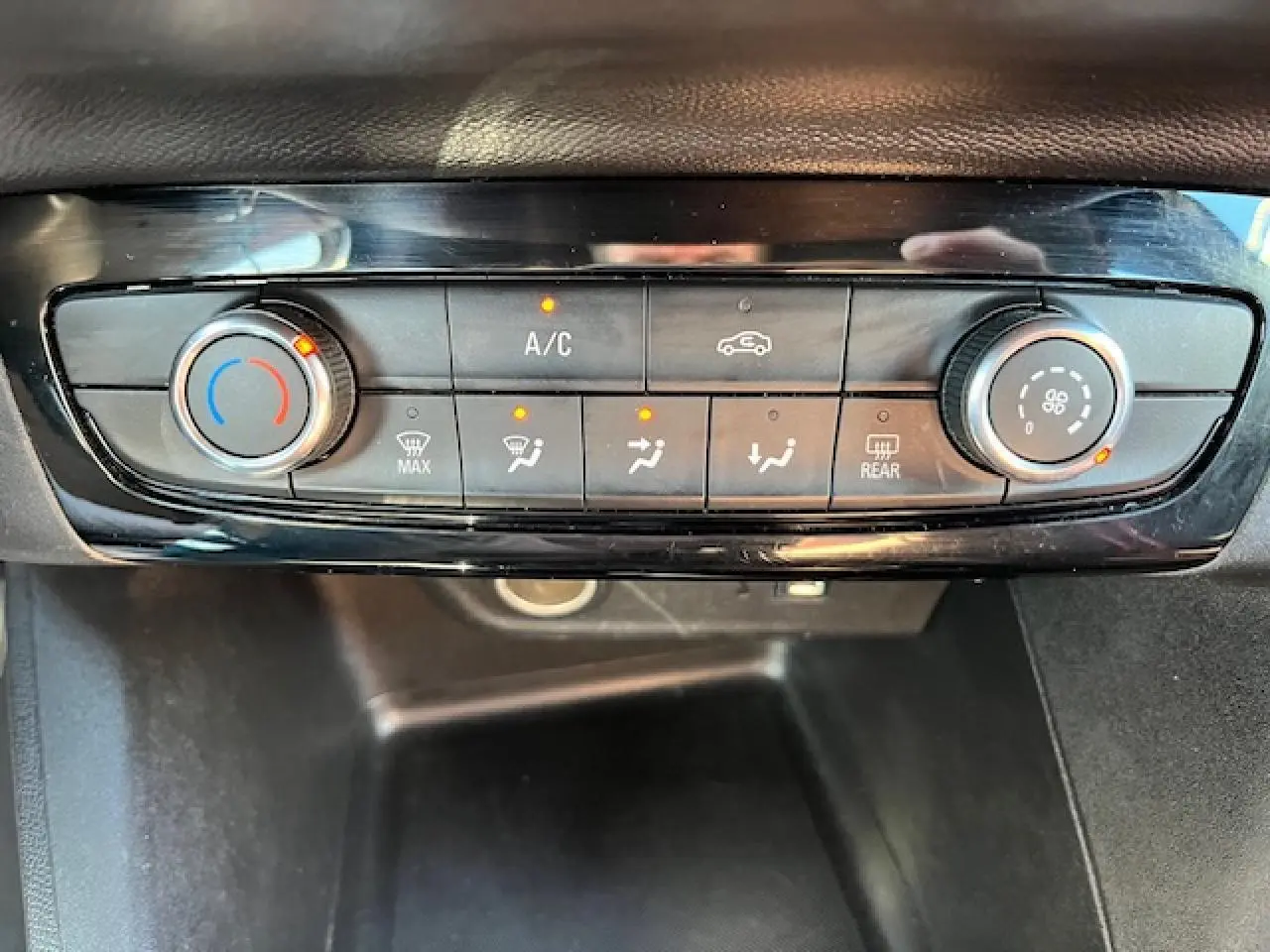 Gros plan sur la console de climatisation de l'Opel Corsa 1.2i Turbo 2021 avec commandes digitales et boutons rétroéclairés.