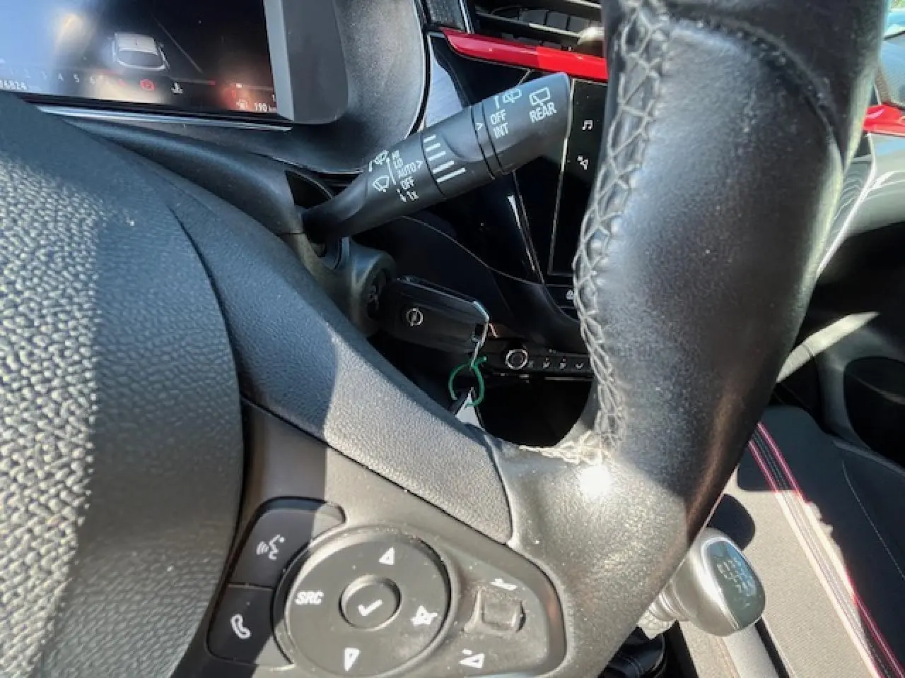 Gros plan sur le volant cuir multifonction et levier de vitesse manuel de l'Opel Corsa gris/noir, intérieur moderne et lumineux.