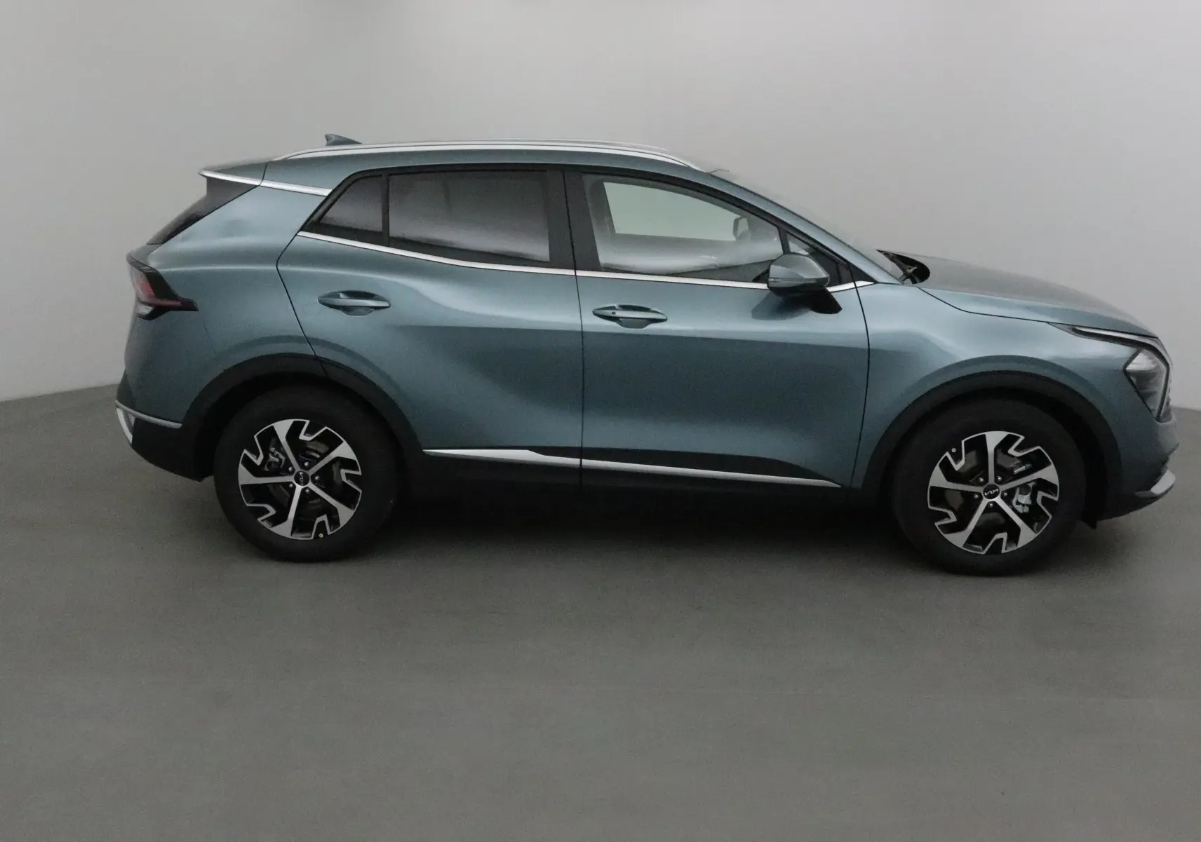 Profil côté gauche du Kia Sportage gris Sirius 2025 avec jantes alliage et lignes modernes distinctives.