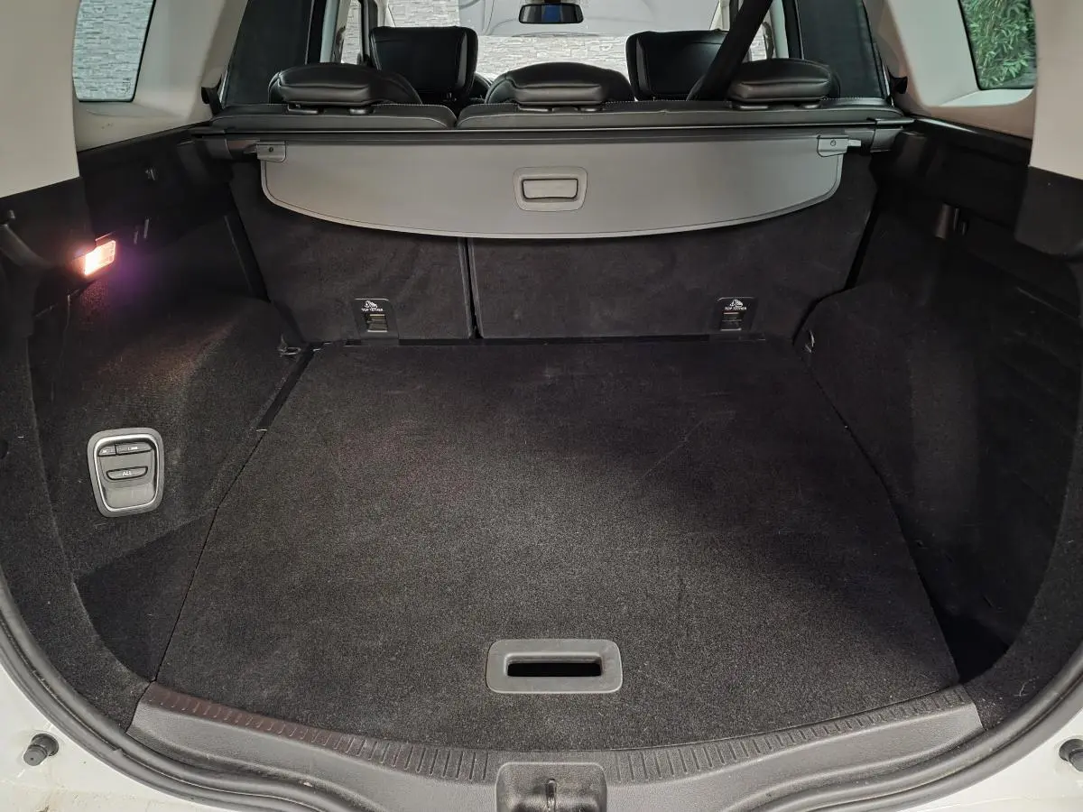 Coffre spacieux du Renault Scénic blanc 2017, vue arrière ouverte avec cache-bagages et éclairage intérieur.