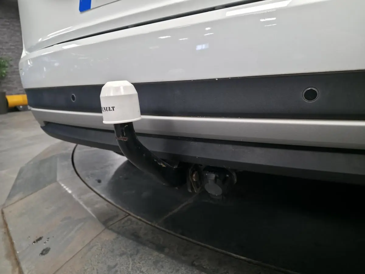 Gros plan sur l'attelage noir avec cache blanc marqué Renault du pare-chocs arrière blanc du Scenic Grand 2017.