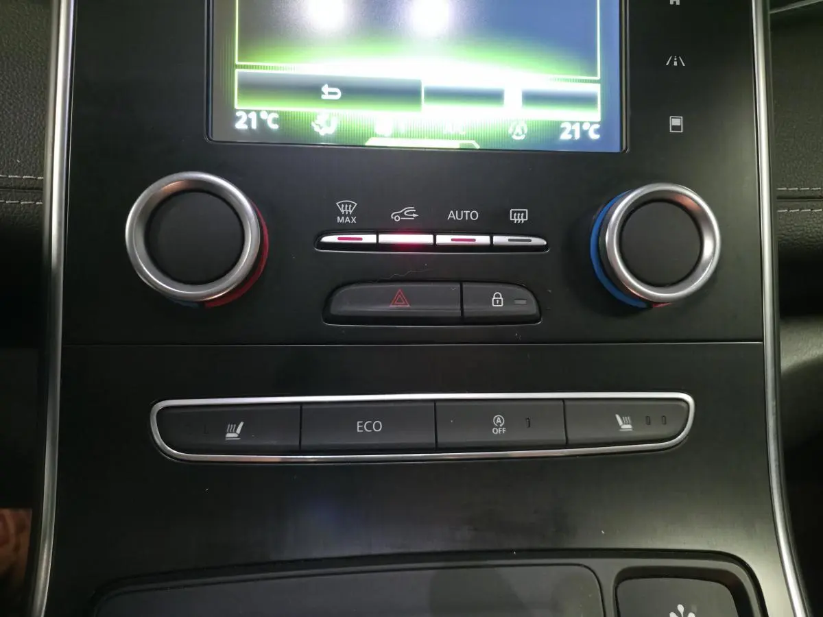 Détail de la console centrale noire du Renault Scenic blanc 2017 avec commandes climatisation et boutons ECO et sièges chauffants.