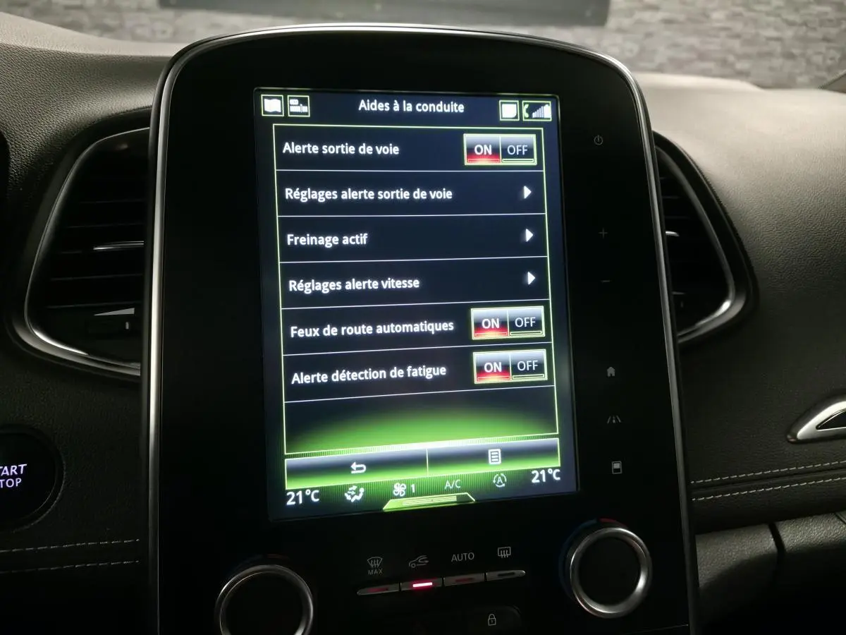 Écran tactile central du tableau de bord du Renault Scénic blanc 2017 affichant les aides à la conduite.