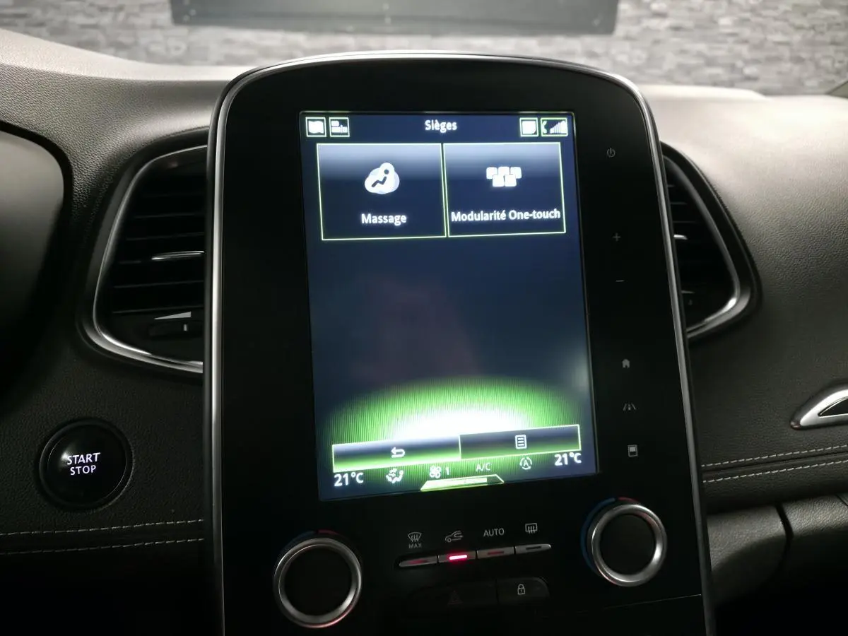 Écran tactile central du tableau de bord du Renault Scénic blanc 2017, affichant les options massage et modularité One-touch.