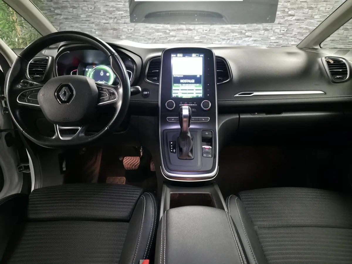 Intérieur noir du Renault Scénic 2017, vue frontale du tableau de bord avec écran tactile vertical et volant cuir.
