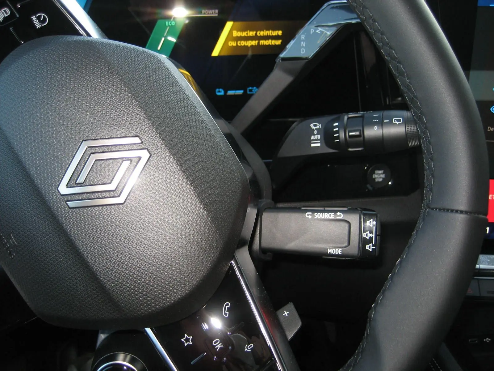 Gros plan sur le volant et les commandes du tableau de bord du Renault Austral PH.2, affichage digital avec message de sécurité.