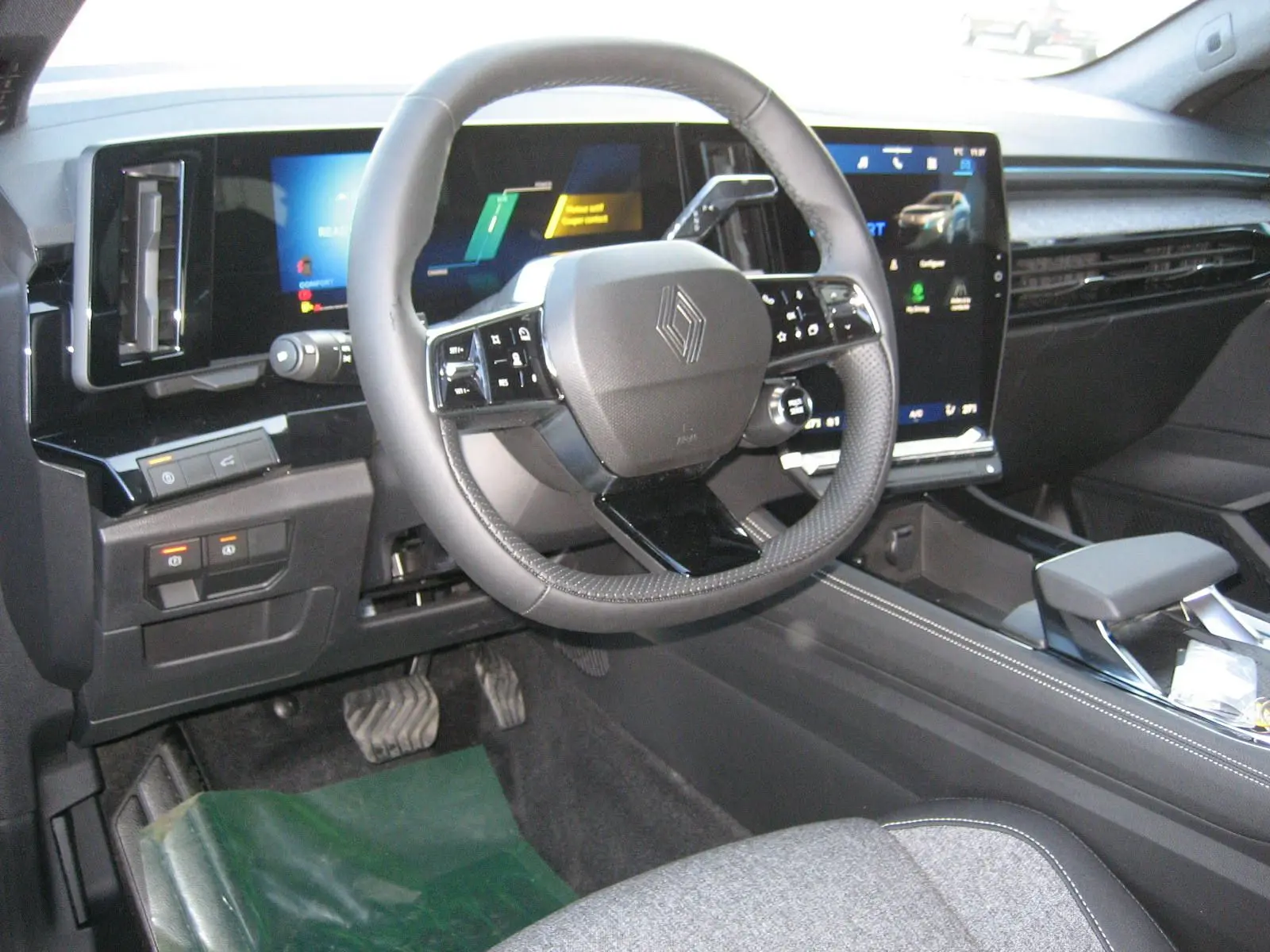 Vue intérieure centrée sur le volant et le tableau de bord numérique du Renault Austral 2025, ambiance moderne et épurée.