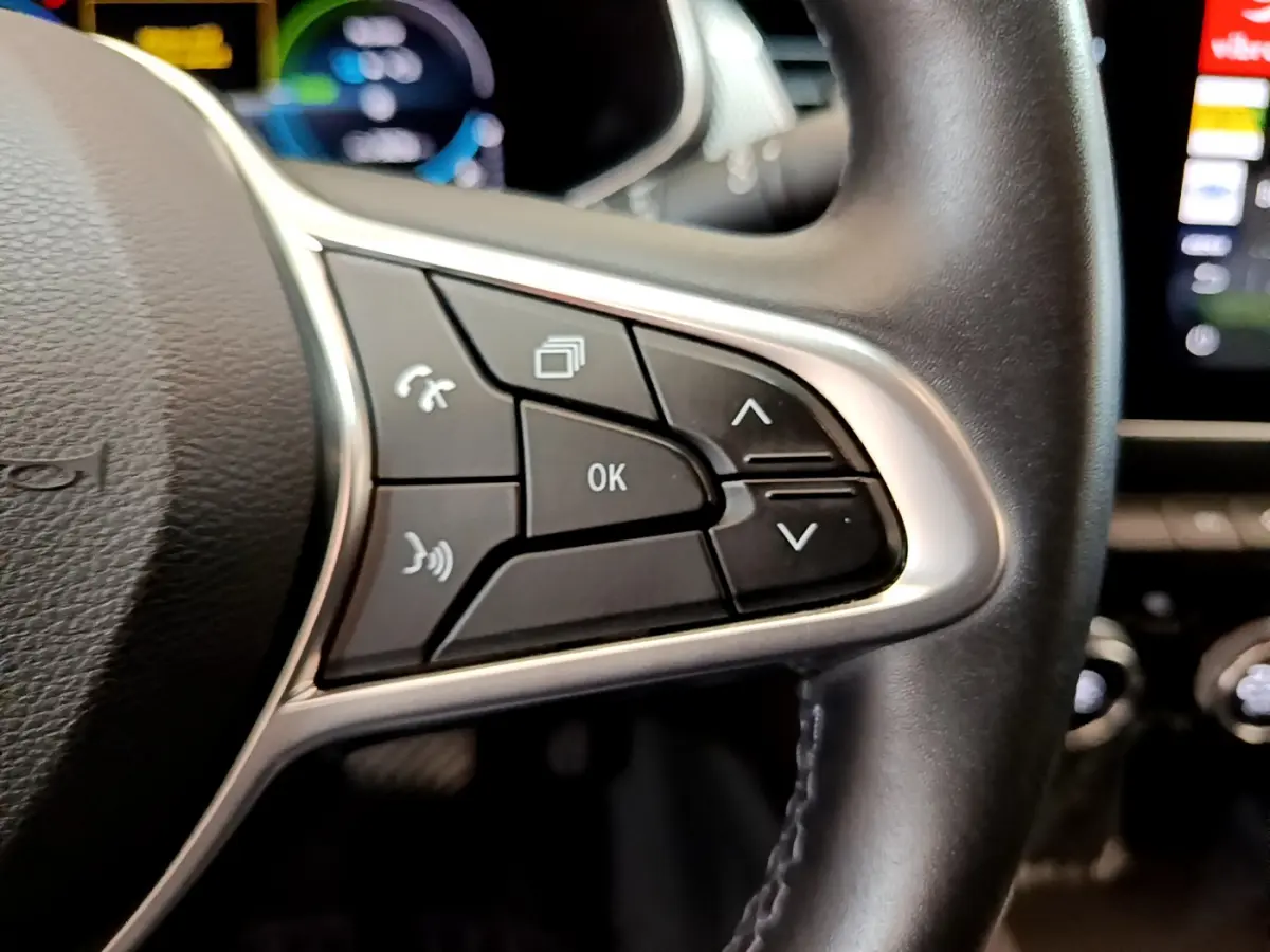 Gros plan sur les commandes multifonctions côté droit du volant cuir du Renault Arkana bleu hybride 2023.