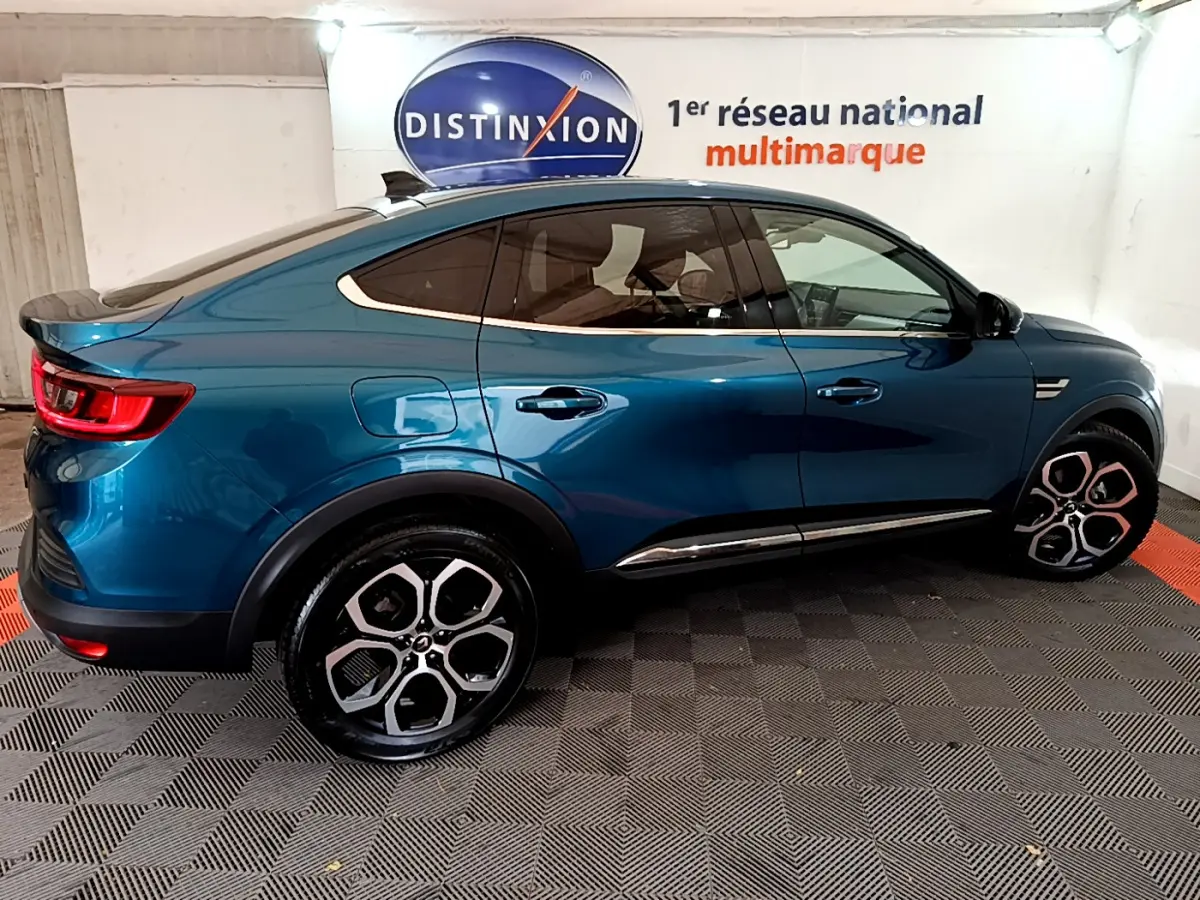 Renault Arkana Techno E-Tech hybride bleu en vue profil côté gauche, soulignant ses lignes fluides et jantes distinctives.