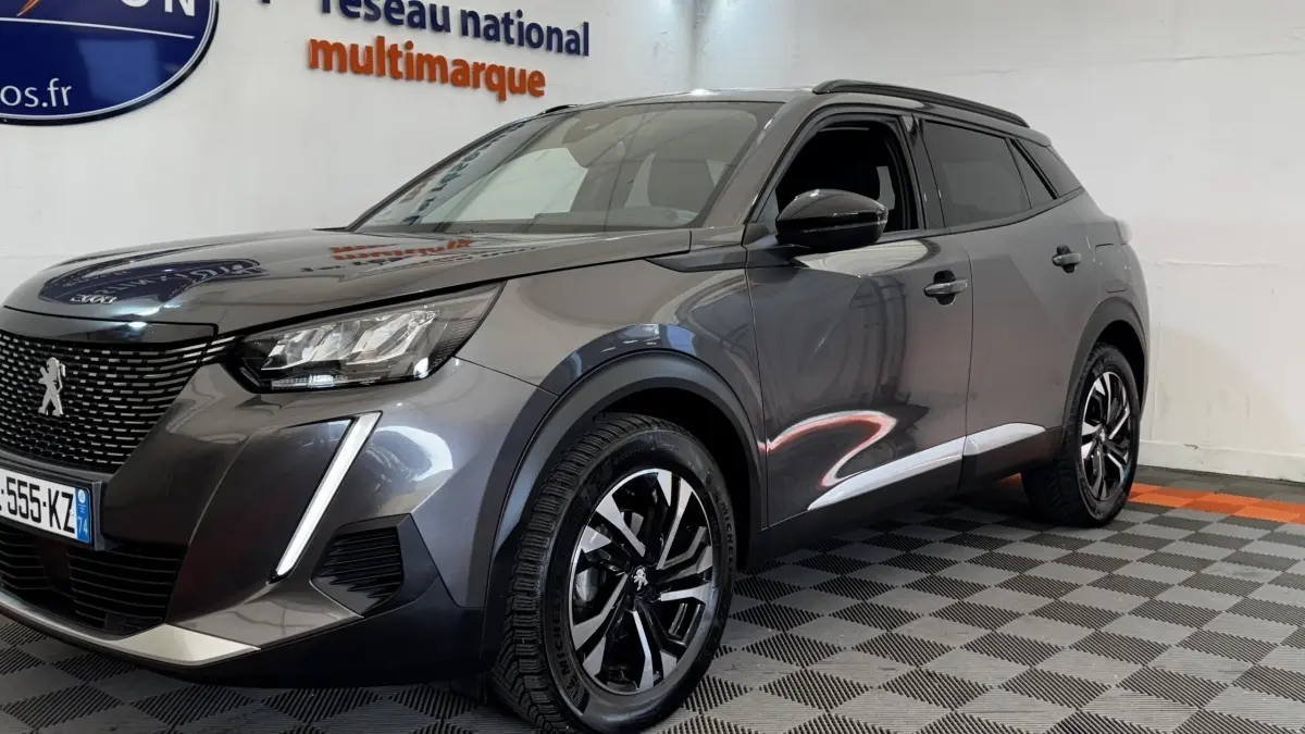Peugeot 2008 gris foncé vue 3/4 avant droit, avec feux LED et jantes alliage noires distinctives.