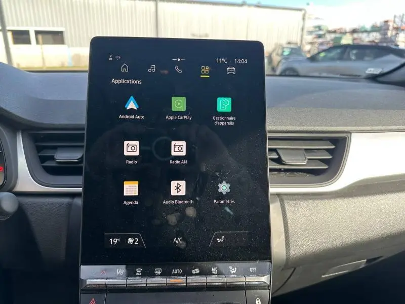 Écran tactile central vertical du tableau de bord du Renault Captur blanc nacré/noir, affichant les applications connectées.