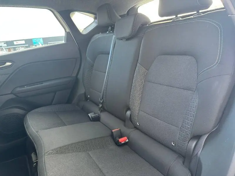 Vue intérieure côté gauche de la banquette arrière noire avec surpiqûres blanches du Renault Captur 2025 blanc nacré/noir étoile.