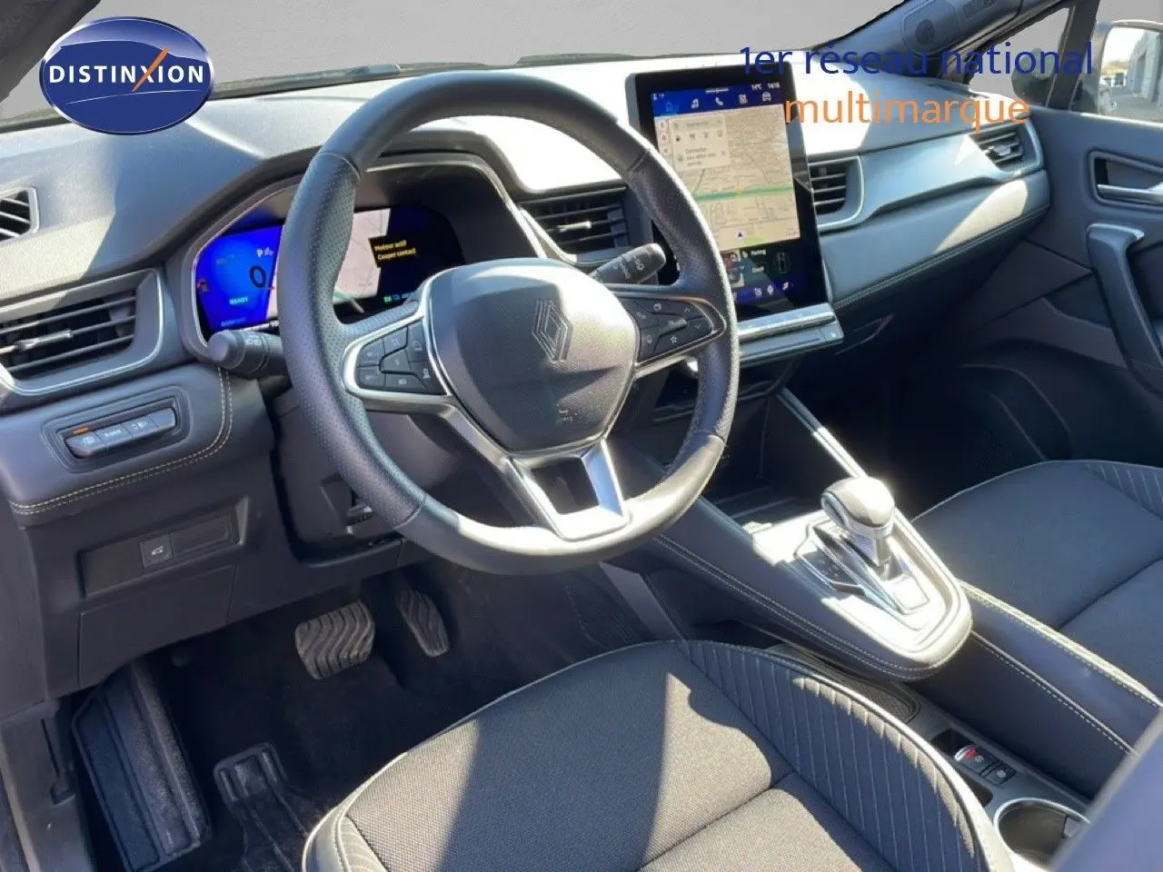 Intérieur noir de la Renault Symbioz 2025, vue côté conducteur sur volant, écran tactile vertical et levier de vitesse automatique.