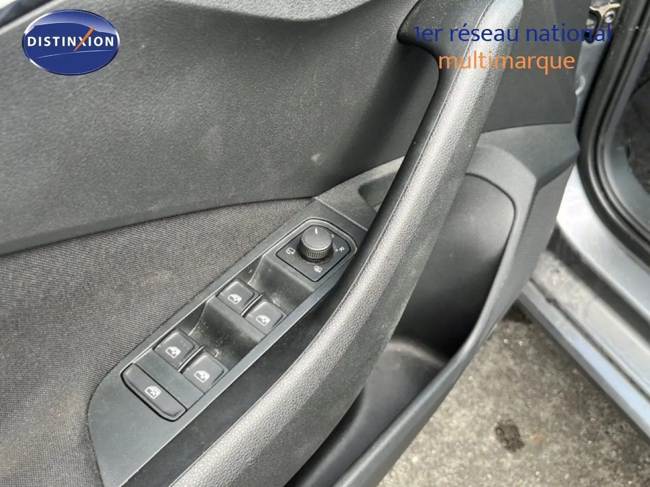 Détail de la porte côté gauche d'une Skoda Scala gris magnétique, montrant les commandes des vitres et rétroviseurs.