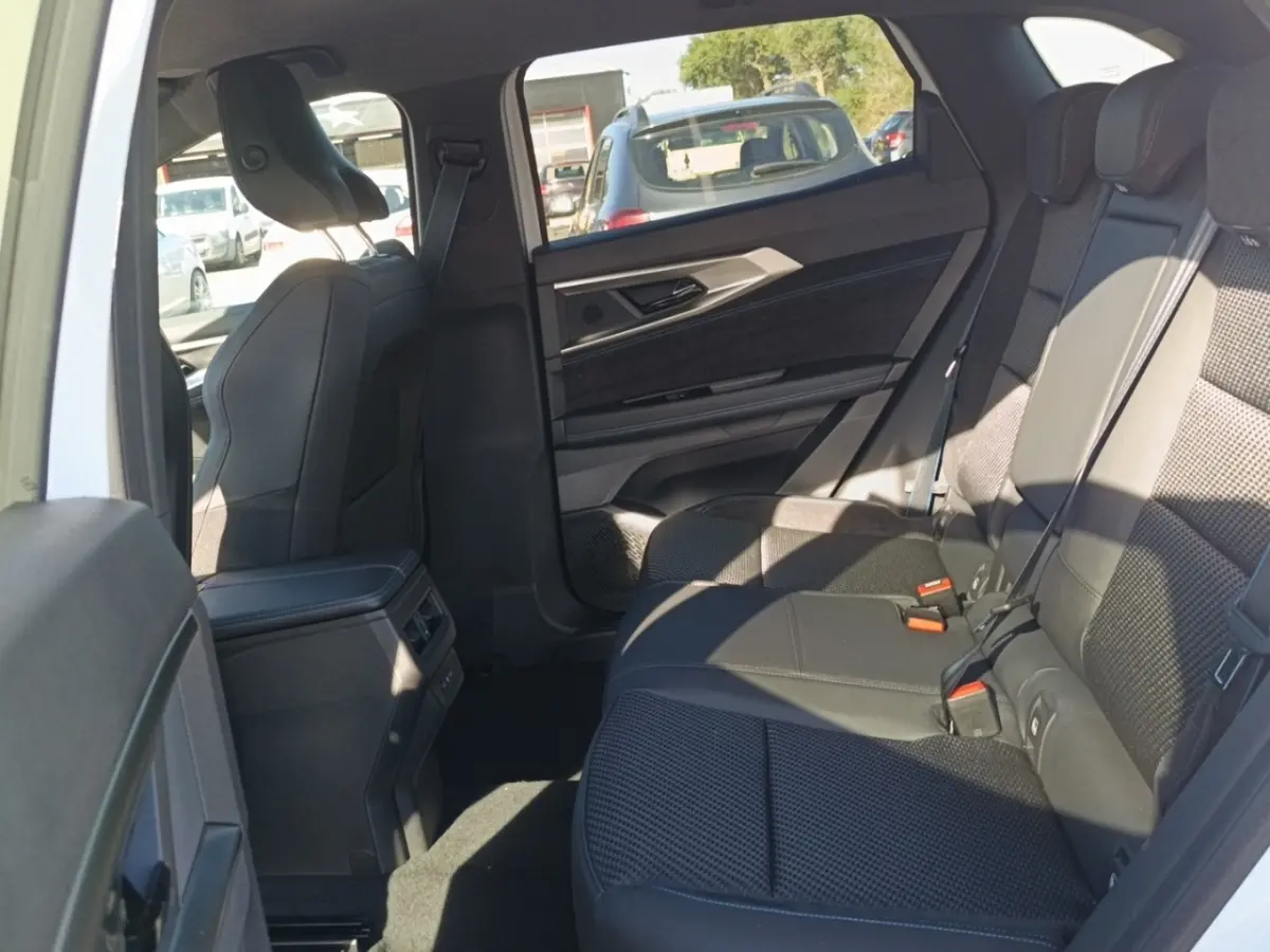Vue intérieure côté droit des sièges arrière noirs du Renault Austral Esprit Alpine blanc, avec habillage de porte et console centrale visibles.