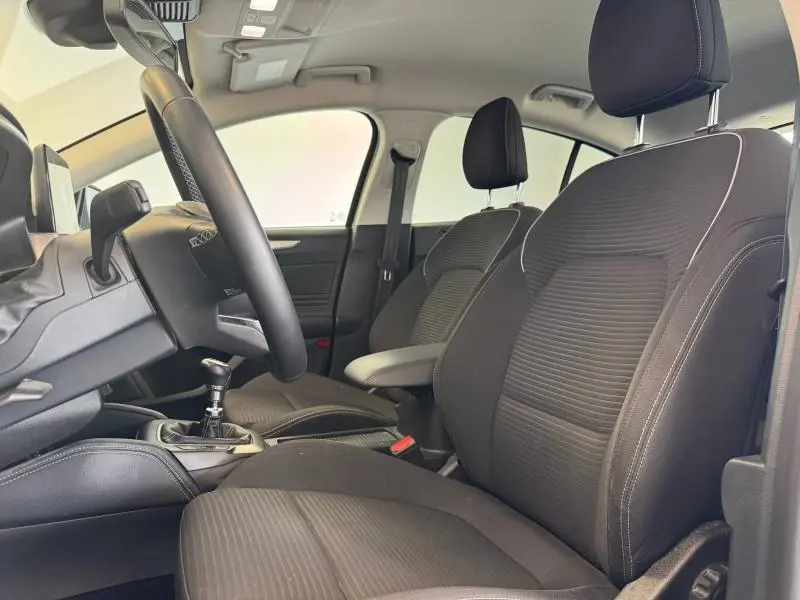 Vue intérieure côté conducteur de la Ford Focus 2021 avec sièges tissu noir et volant cuir multifonction.