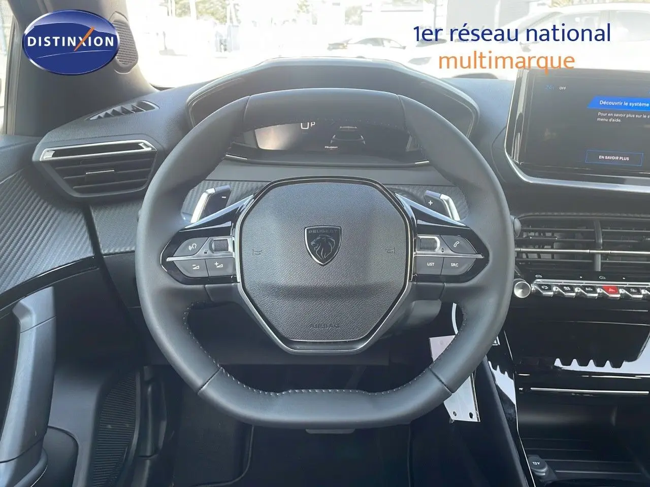Vue rapprochée du volant cuir noir du Peugeot 2008 Hybrid 136ch Allure 2025 avec tableau de bord digital.