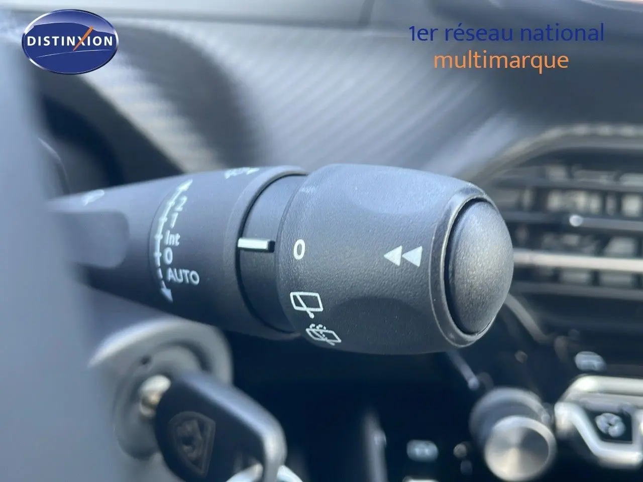 Gros plan sur la commande d'essuie-glace du Peugeot 2008 gris Artense, montrant les réglages au tableau de bord.