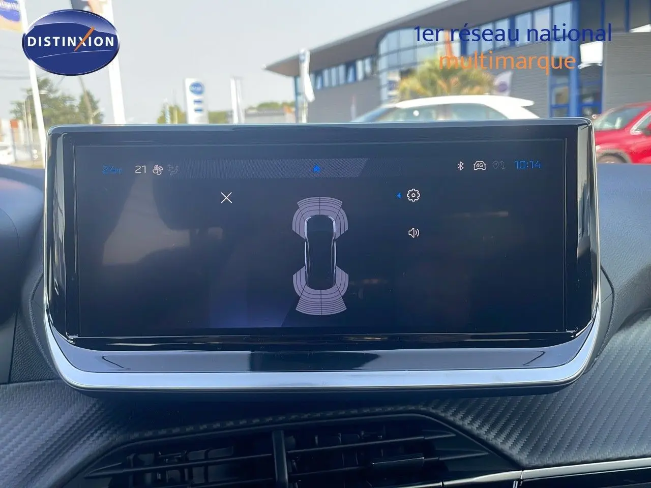 Écran tactile central affichant l'aide au stationnement dans un Peugeot 2008 Hybride 2025, intérieur moderne.