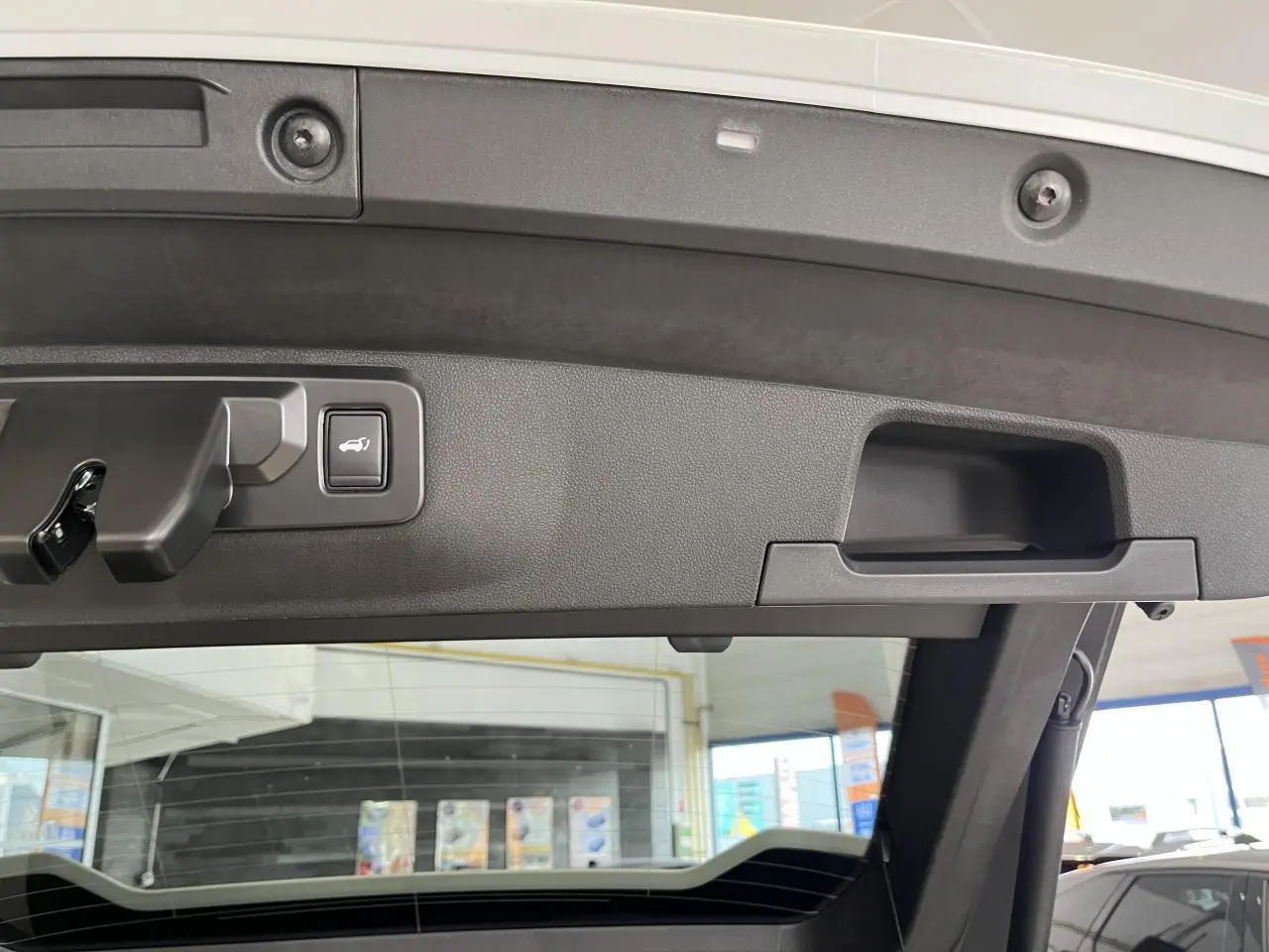 Détail du hayon motorisé blanc du Renault Rafale 2025 vu de l'intérieur avec bouton d'ouverture intégré.