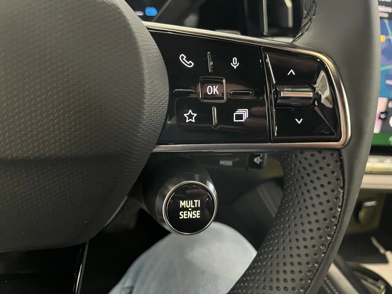 Gros plan sur le volant perforé avec commandes intégrées et bouton Multi-Sense du Renault Rafale blanc 2025.