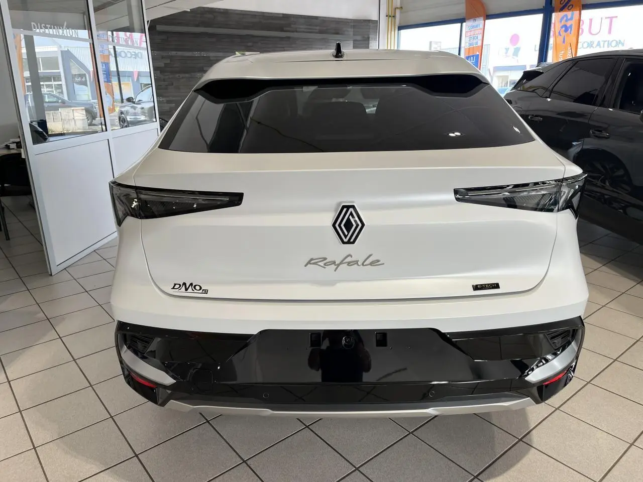 Vue arrière d'une Renault Rafale blanche 2025 avec feux arrière LED et hayon motorisé en showroom.