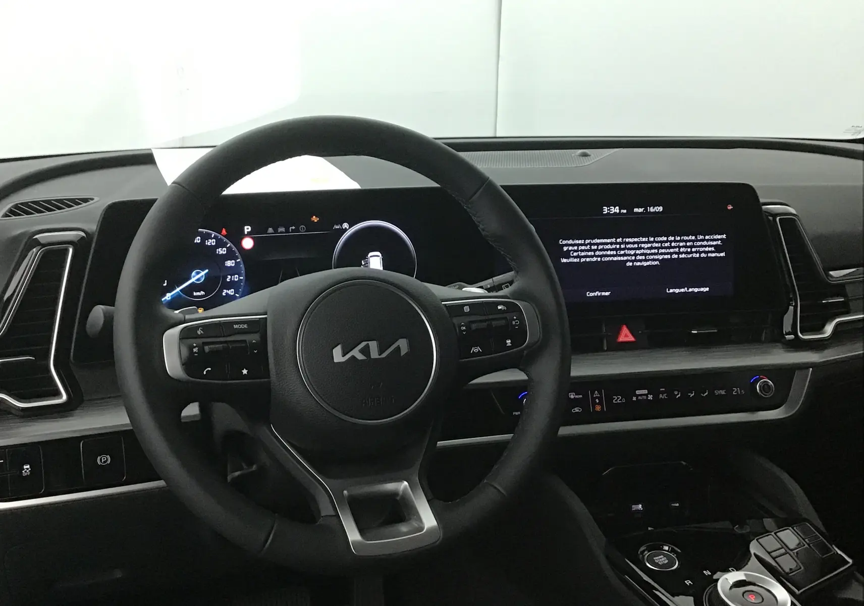 Intérieur du Kia Sportage 2025 montrant le volant cuir et l'écran digital 12,3 pouces du tableau de bord.