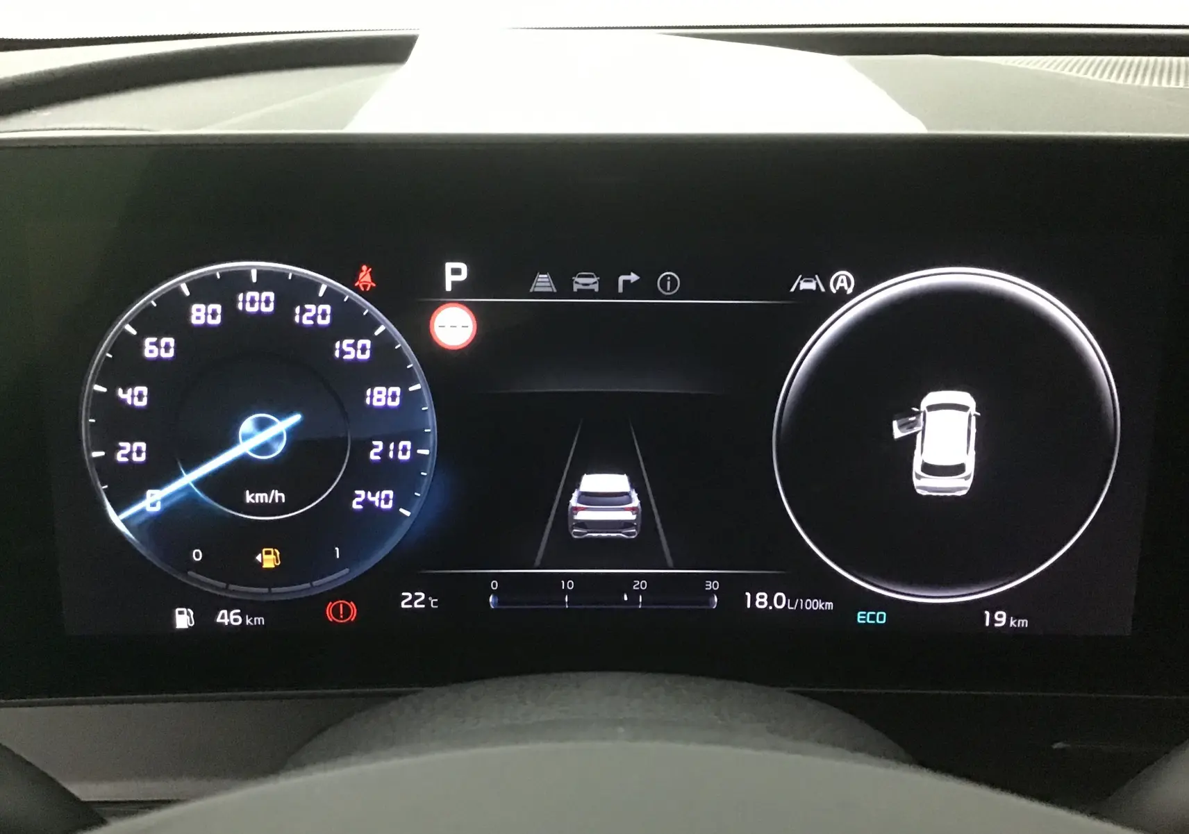 Combiné d'instrumentation digital 12,3'' du Kia Sportage gris Sirius, affichant vitesse, consommation et porte ouverte côté gauche.