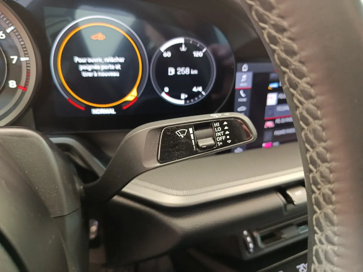 Gros plan sur la commande d’essuie-glace et le tableau de bord digital d’une Porsche 911 Carrera 4S Coupé gris foncé.