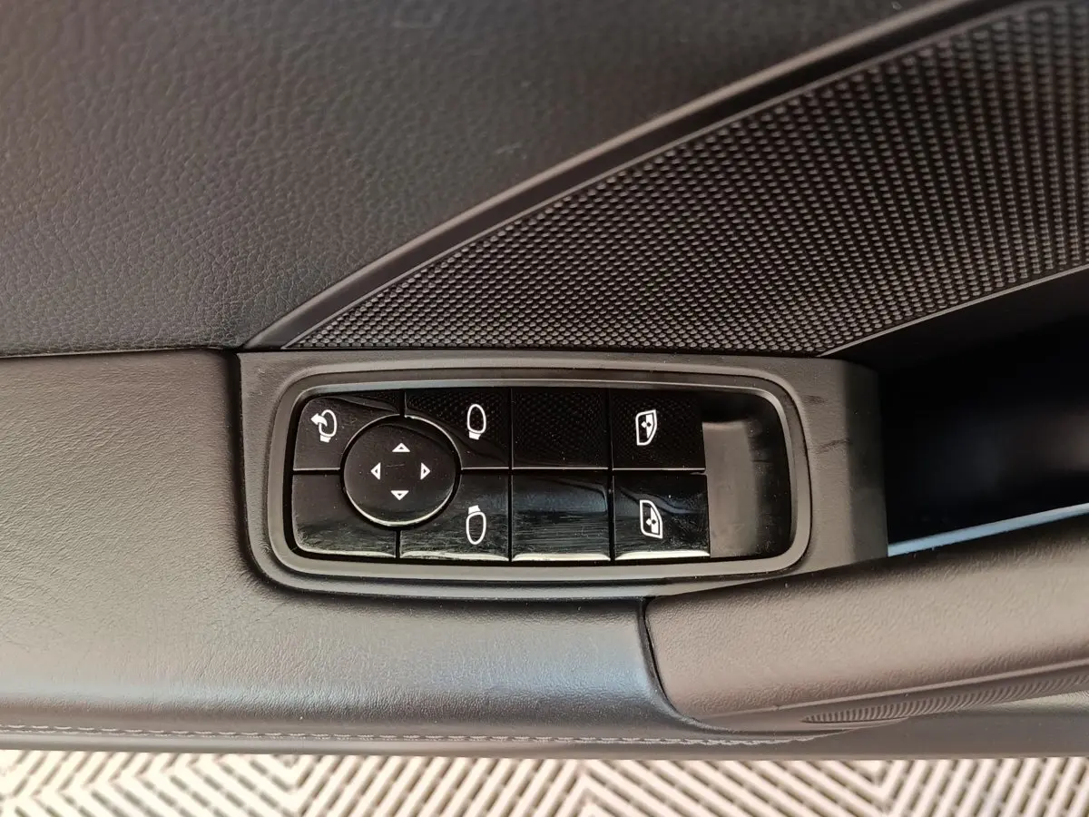 Gros plan sur les commandes électriques des rétroviseurs et vitres côté gauche d’une Porsche 911 Carrera 4S Coupé gris foncé.