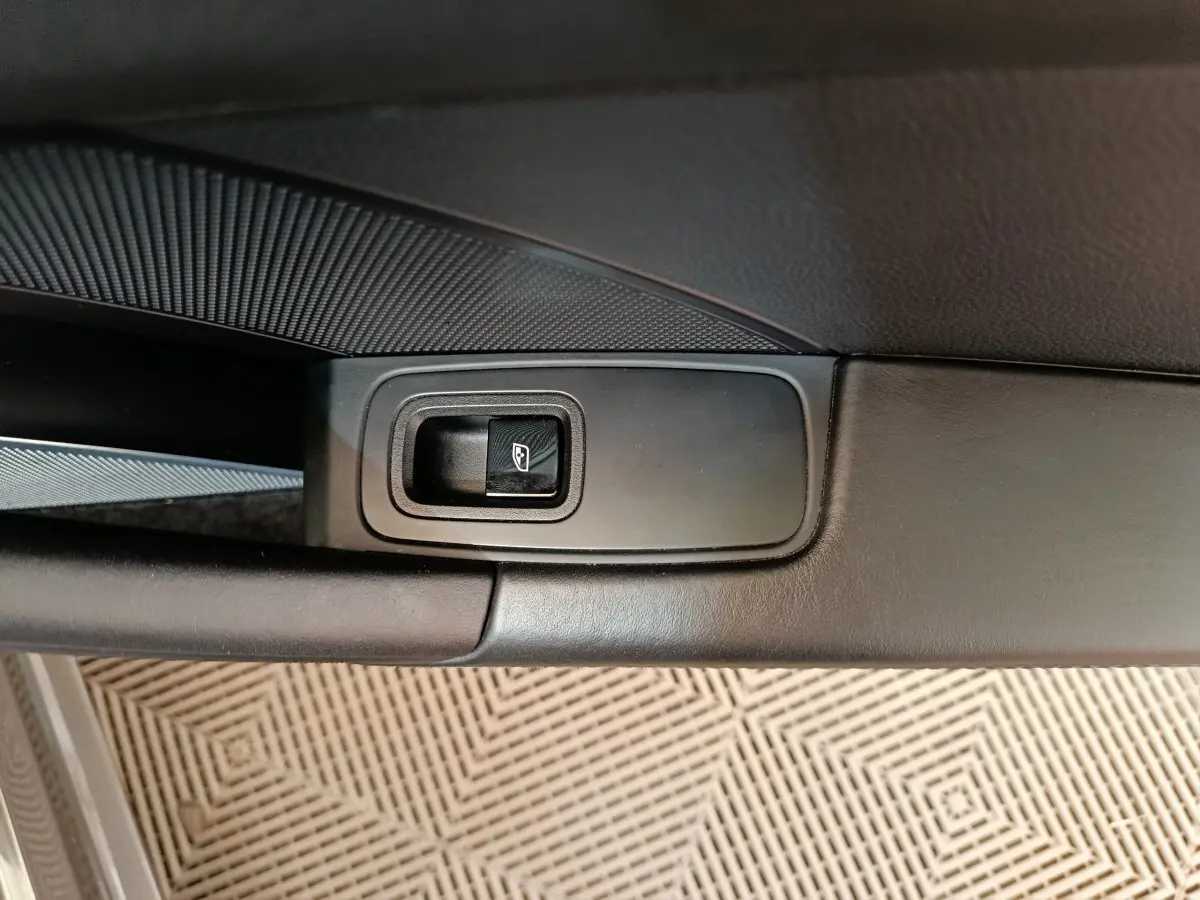 Gros plan sur le bouton de commande de la vitre côté conducteur, intérieur cuir noir de la Porsche 911 Carrera 4S 2019.