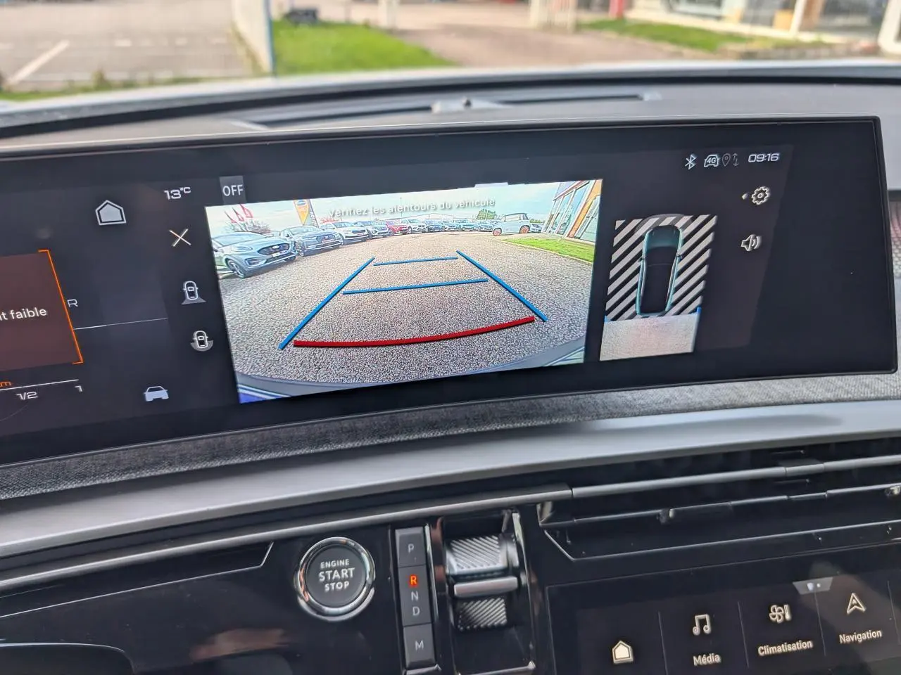 Vue intérieure sur l'écran tactile affichant la caméra de recul du Peugeot 3008 blanc, avec commandes et bouton start visibles.
