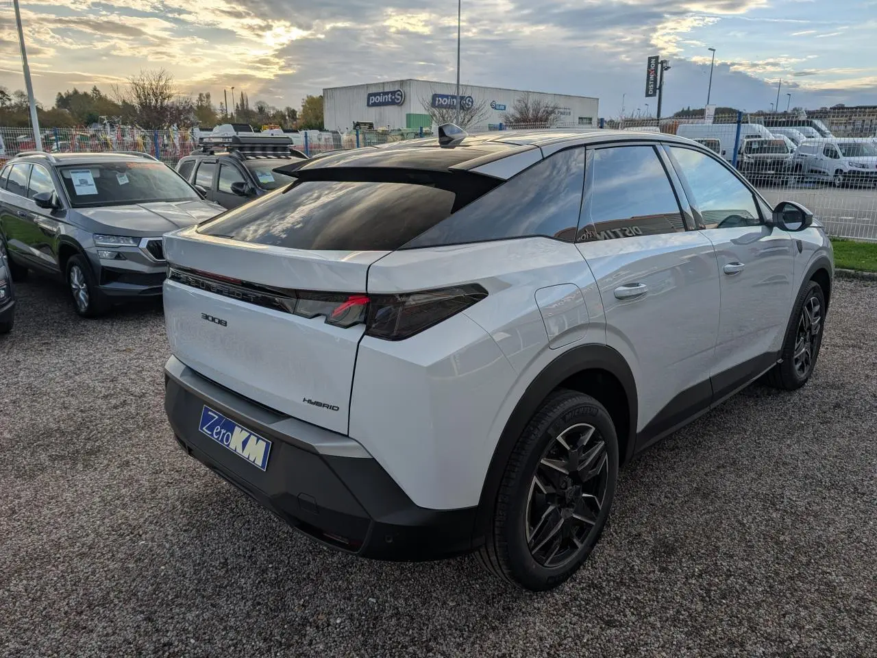 Peugeot 3008 blanc vue 3/4 arrière droit, toit noir, feux arrière à griffes LED et jantes alliage noires.