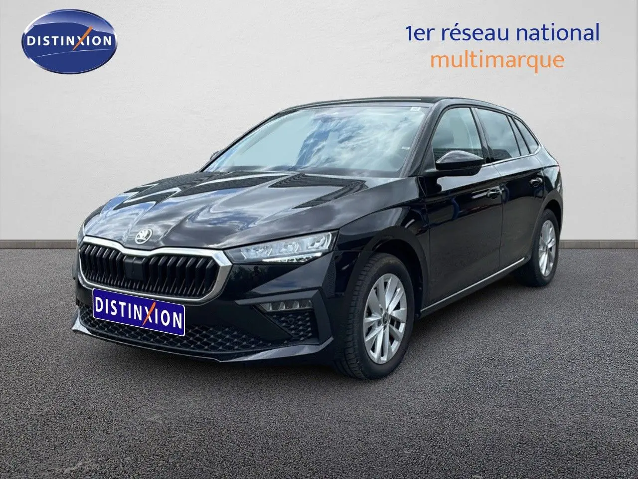 Vue 3/4 avant droite d'une Skoda Scala noire métallisée avec calandre distinctive et jantes argentées.