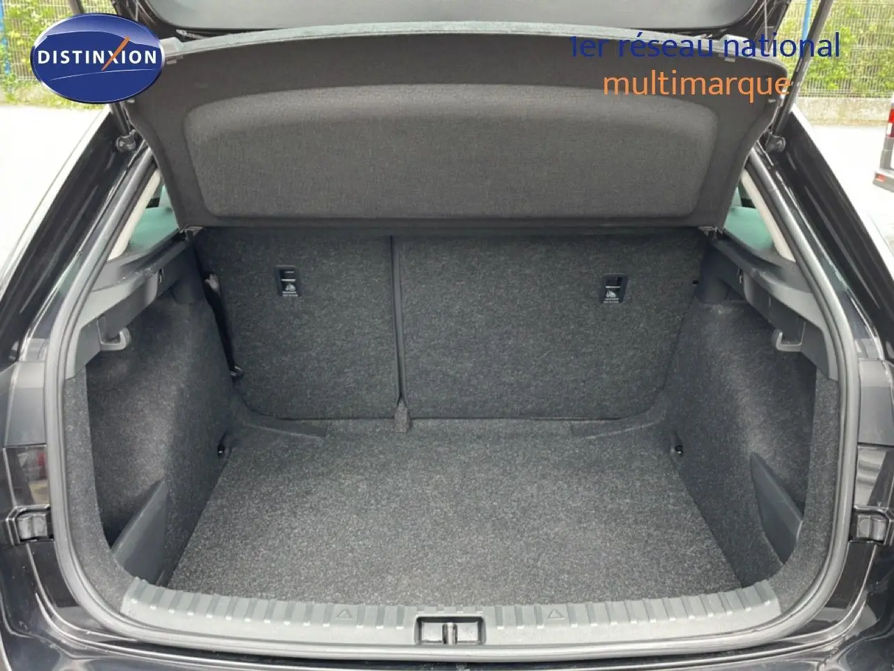 Coffre ouvert vu de l'arrière d'une Skoda Scala noir magique métal, montrant un espace de chargement propre et spacieux.
