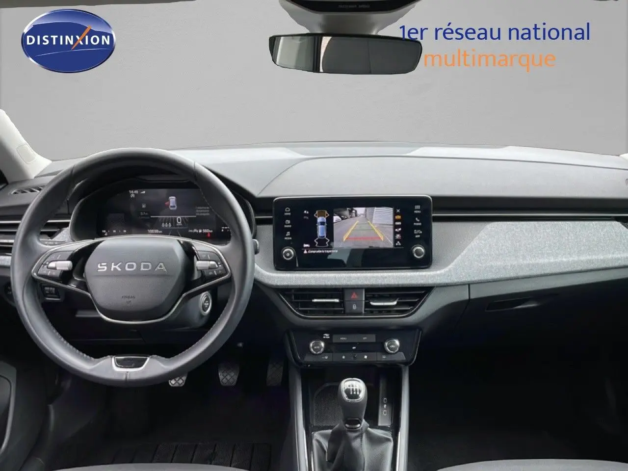 Vue intérieure frontale du Skoda Scala 2025 noir magique métal, avec tableau de bord numérique et écran central affichant la caméra de recul.