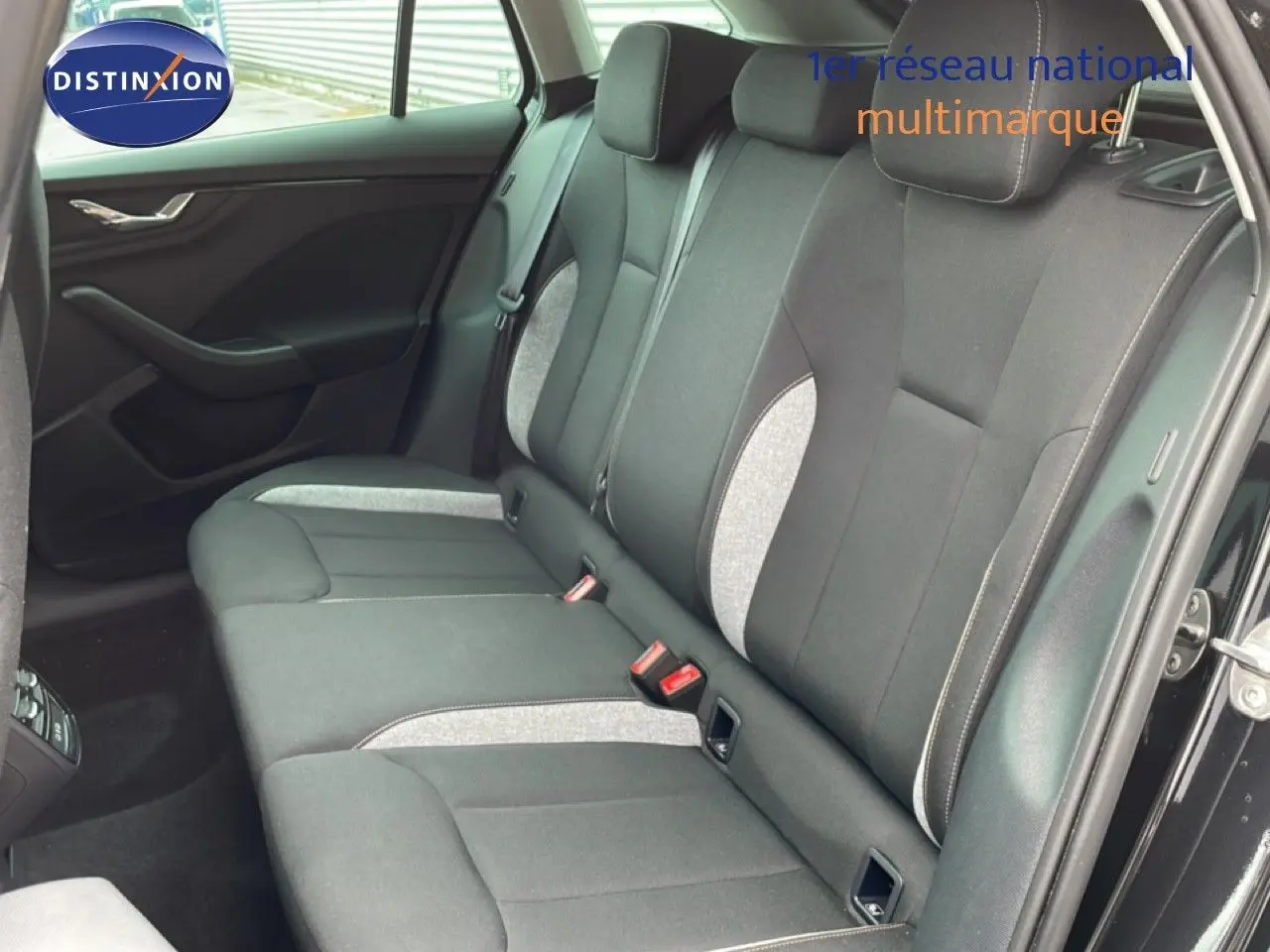 Vue intérieure côté droit montrant la banquette arrière en tissu gris noir d'une Skoda Scala 2025 noir magique métal.