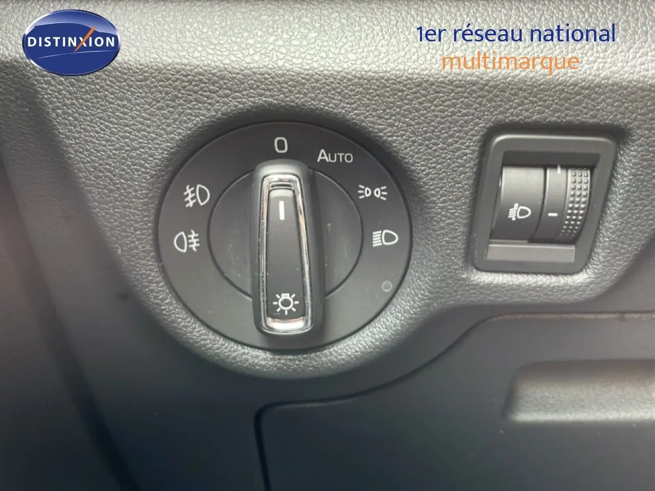 Gros plan sur le sélecteur de phares et le réglage d’intensité lumineuse intérieur d’une Skoda Scala noire.