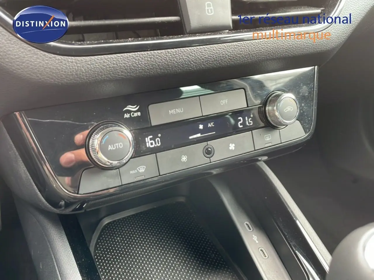 Gros plan sur la console centrale de la Skoda Scala noire, mettant en valeur les commandes de climatisation digitale.