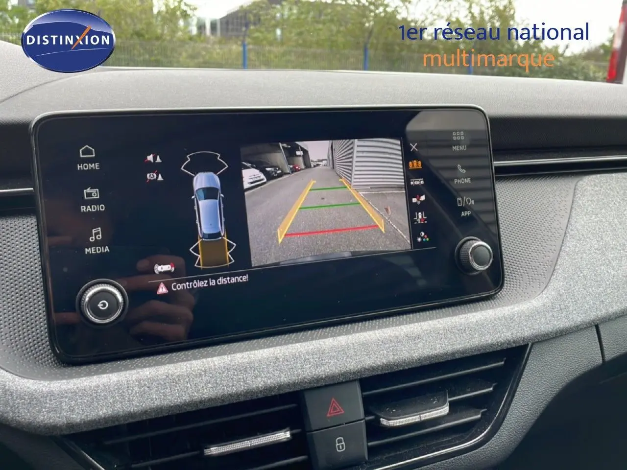 Écran central de la Skoda Scala 2025 montrant la caméra de recul avec affichage des distances, intérieur gris noir.