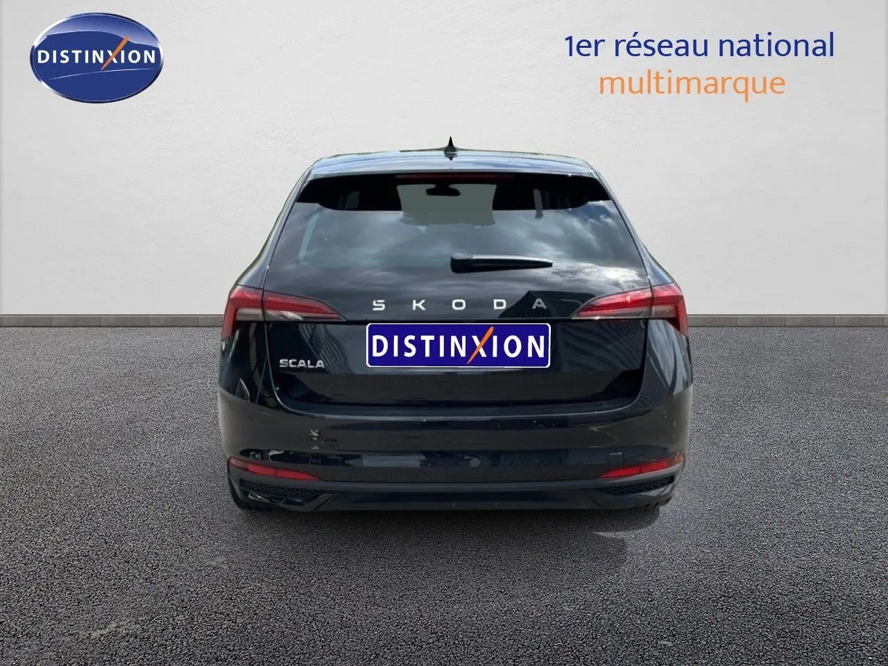 Vue arrière d'une Skoda Scala noire métal, avec feux arrière allongés et logo distinctif bien visible.