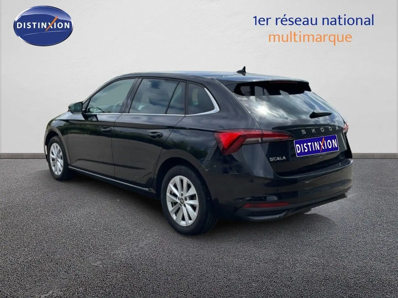 Vue 3/4 arrière droite d'une Skoda Scala noire métallique, avec feux arrière allongés et jantes argentées.